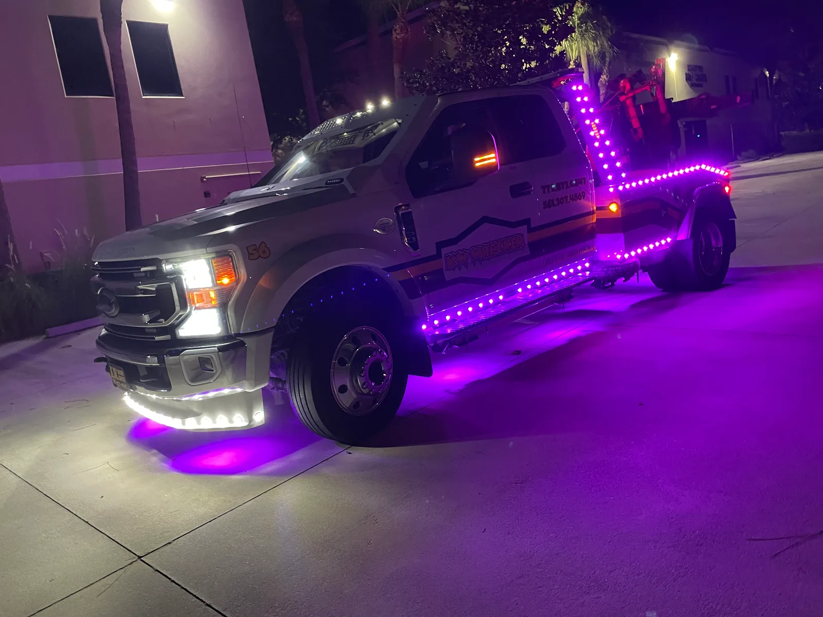 KW Wrecker Service light-duty wrecker with custom purple LED lighting at night