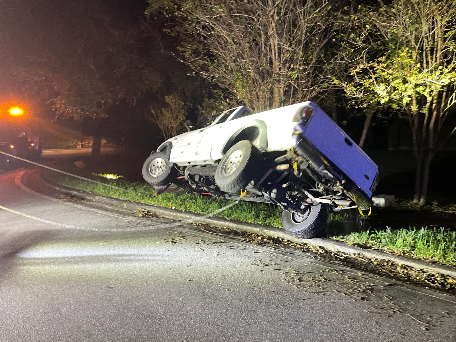 KW Wrecker Service nighttime roadside recovery of an overturned pickup truck