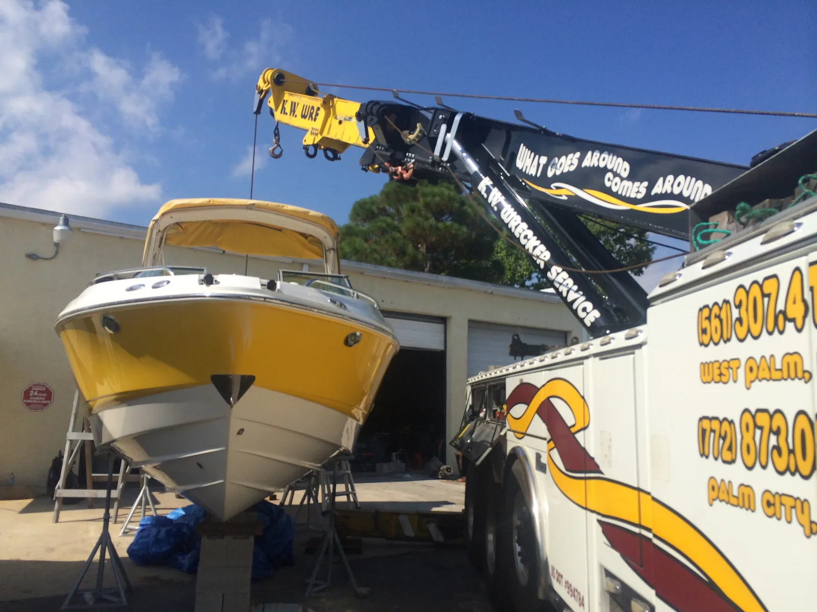 KW Wrecker Service heavy-duty wrecker positioning a boat at a marine facility