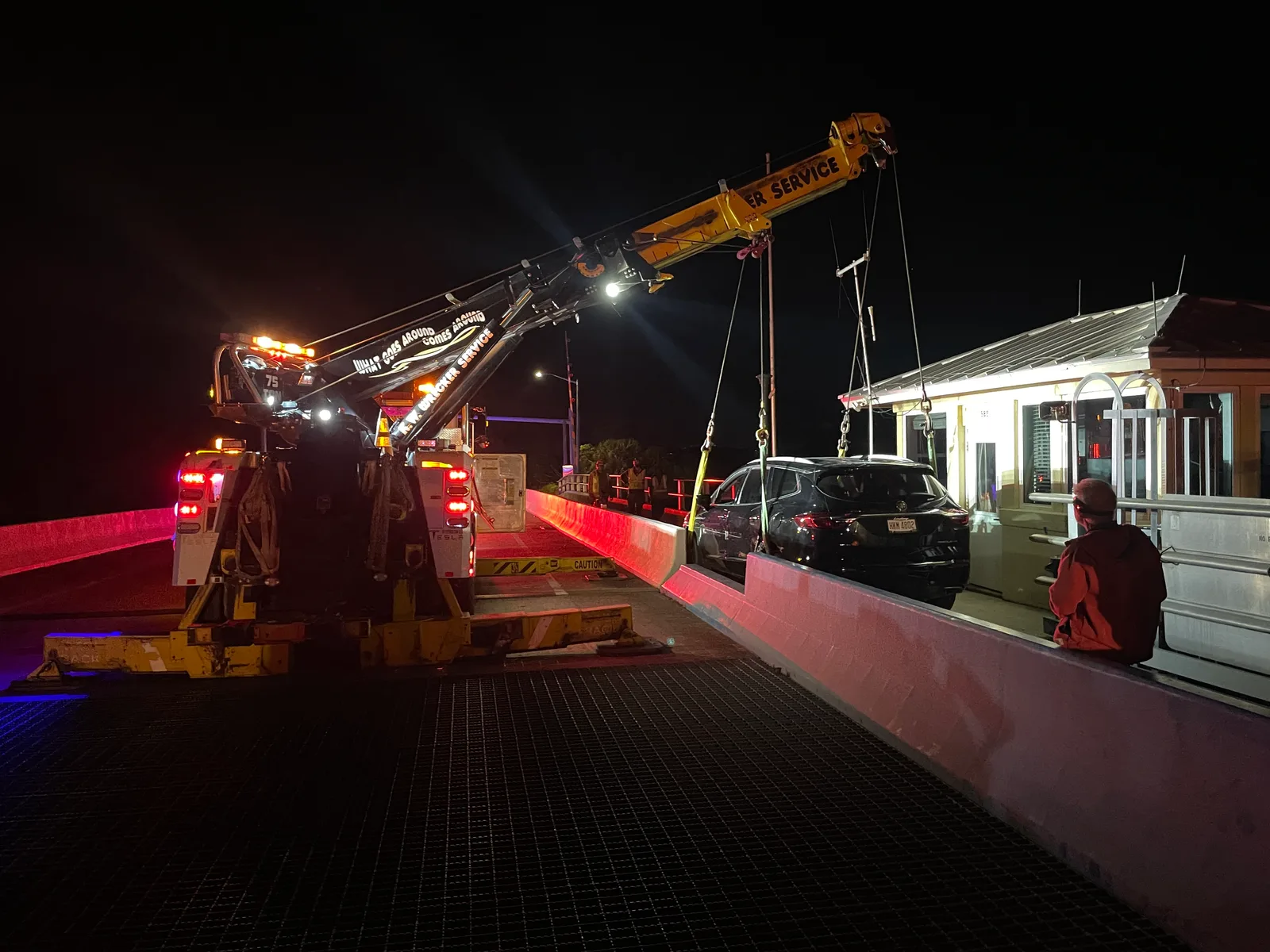 KW Wrecker Service 75-ton rotator performing a nighttime vehicle recovery on a drawbridge